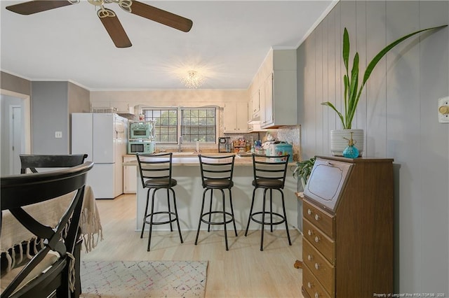 1810 Ashton Rd, Fayetteville, NC 28304 - kitchen with ceiling fan, freestanding refrigerator, a peninsula, light wood-style floors, and ornamental molding