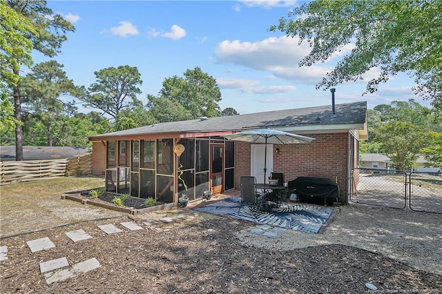 1810 Ashton Rd, Fayetteville, NC 28304 - rear view of house featuring a gate, a sunroom, a patio area, brick siding, and fence