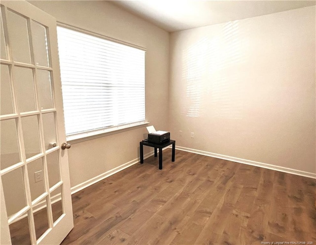 unfurnished room with baseboards, plenty of natural light, and wood finished floors