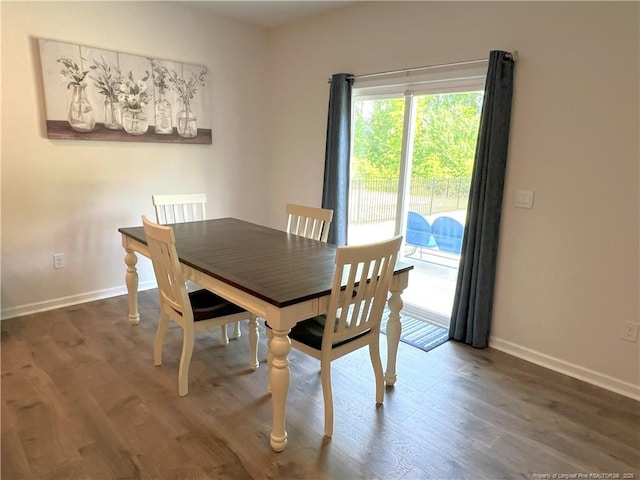 dining area with baseboards and wood finished floors