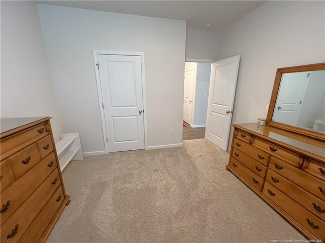 bedroom featuring light colored carpet and baseboards
