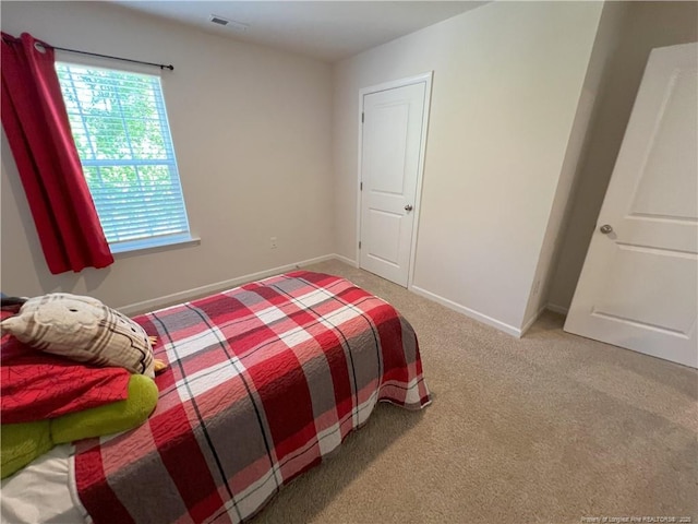 bedroom with carpet floors, baseboards, and visible vents