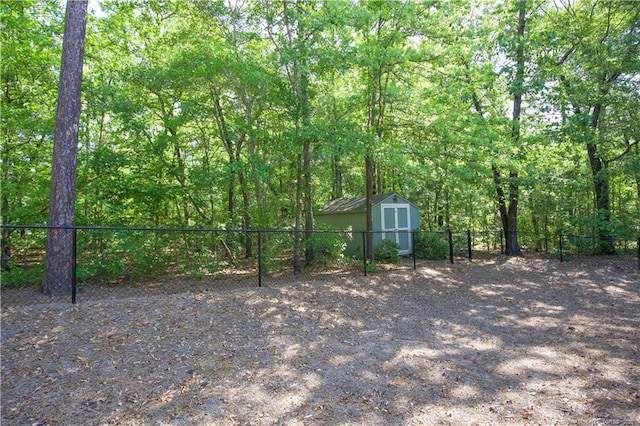 view of yard featuring a storage unit, an outdoor structure, and fence