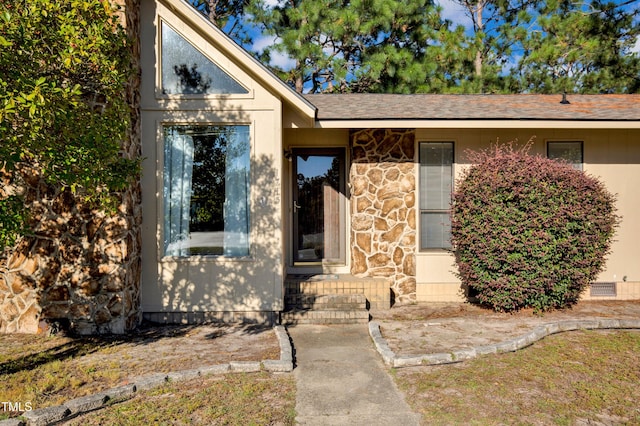 entrance to property with roof with shingles