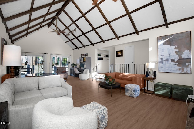 living room featuring ceiling fan, wood finished floors, high vaulted ceiling, and beamed ceiling