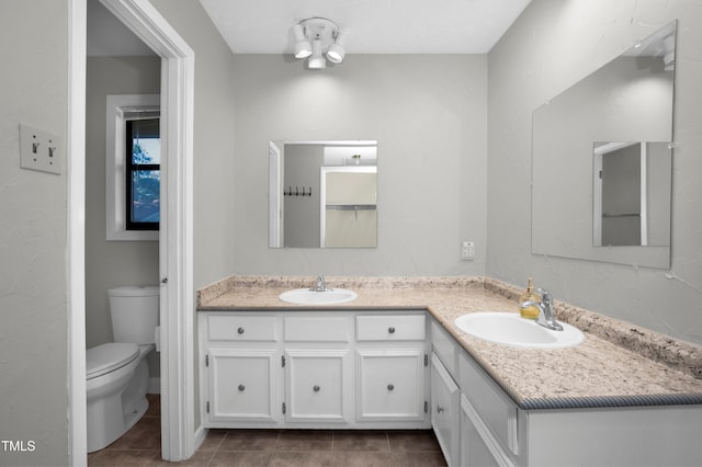 full bath with double vanity, tile patterned floors, and a sink