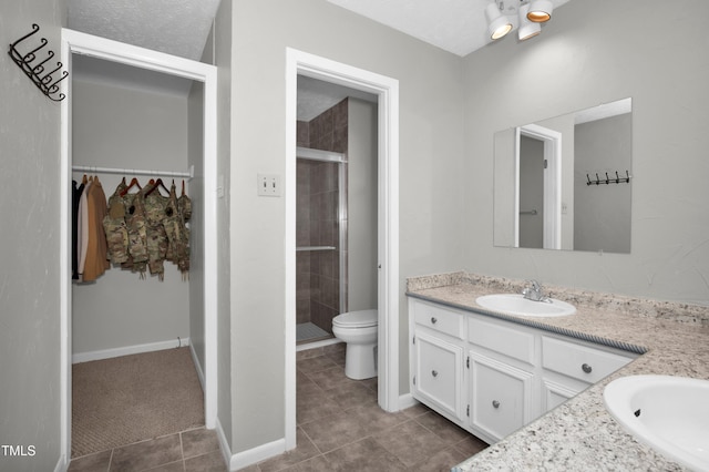 bathroom featuring vanity, tile patterned flooring, a stall shower, and toilet