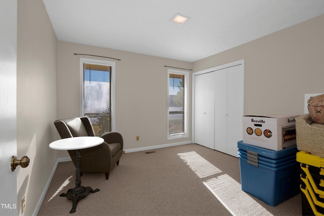 living area featuring baseboards, carpet flooring, and visible vents