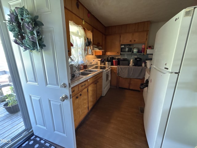 345 Guest Rd, Pelham, NC 27311 - kitchen with dark wood finished floors, light countertops, under cabinet range hood, and white appliances