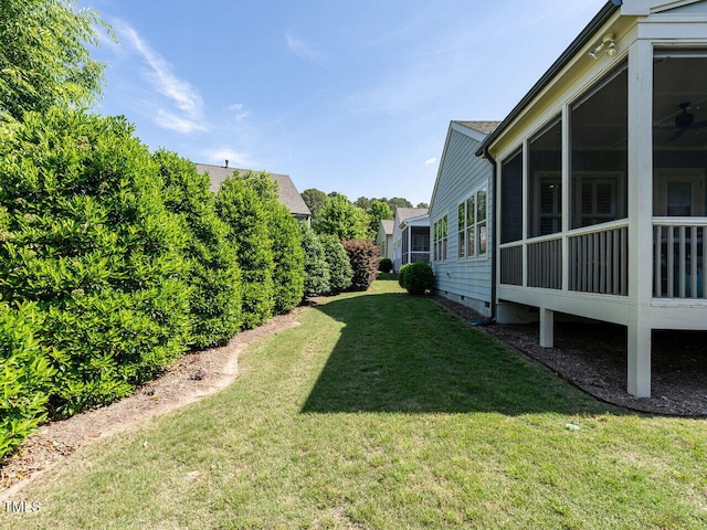 view of green lawn with a sunroom