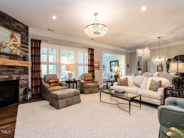 living room featuring a chandelier, ornamental molding, a stone fireplace, wood finished floors, and recessed lighting