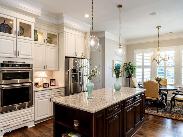 kitchen with appliances with stainless steel finishes, a chandelier, dark brown cabinetry, white cabinets, and crown molding