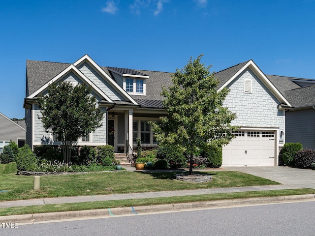 craftsman-style home featuring driveway, a front yard, a garage, a porch, and a shingled roof