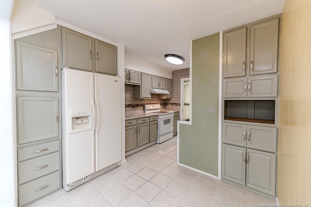 kitchen with light tile patterned floors, gray cabinets, under cabinet range hood, and white appliances