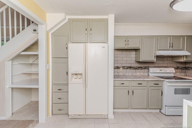 kitchen featuring gray cabinetry, light tile patterned floors, under cabinet range hood, and white appliances