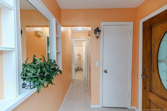 hallway featuring baseboards and light tile patterned floors