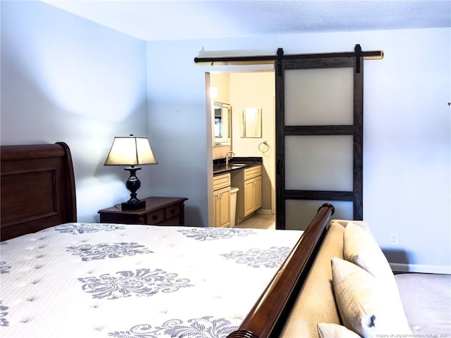 6739 Irongate Dr Unit B, Fayetteville, NC 28306 - bedroom featuring a barn door, a sink, and ensuite bath
