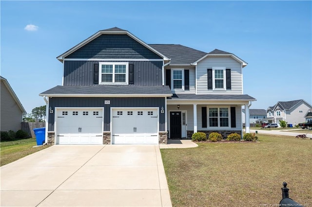 craftsman inspired home with board and batten siding, driveway, a front yard, a garage, and stone siding