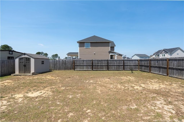 view of yard featuring a storage unit, a fenced backyard, and an outdoor structure