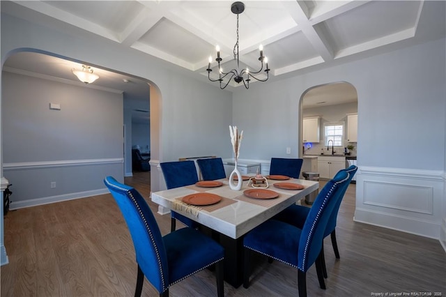 dining room with arched walkways, an inviting chandelier, wood finished floors, and coffered ceiling