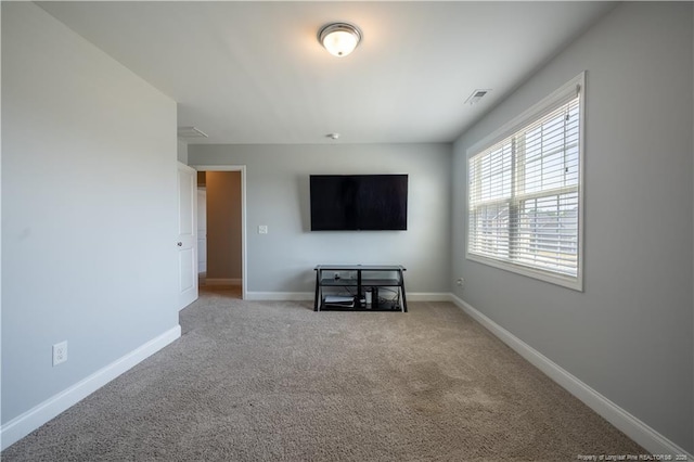 unfurnished living room featuring baseboards and light carpet