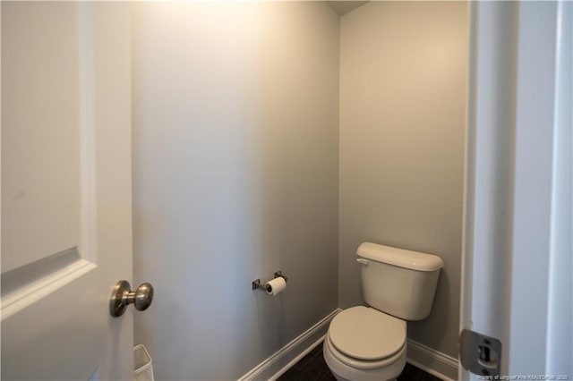bathroom featuring baseboards and toilet