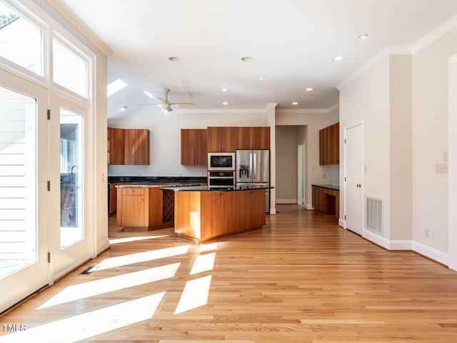 1605 Park Dr, Raleigh, NC 27605 - kitchen featuring stainless steel appliances, visible vents, brown cabinetry, and a healthy amount of sunlight