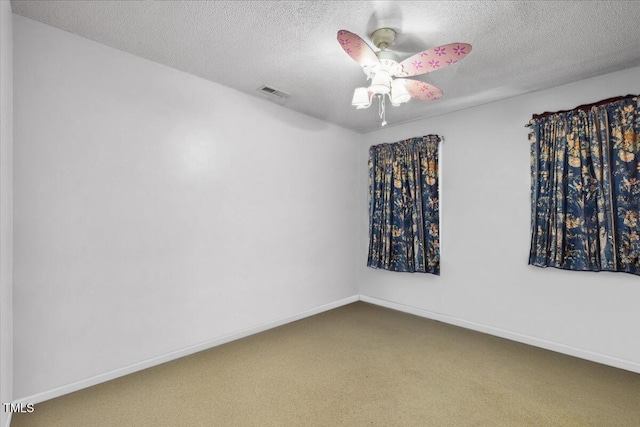carpeted spare room with visible vents, a textured ceiling, and baseboards