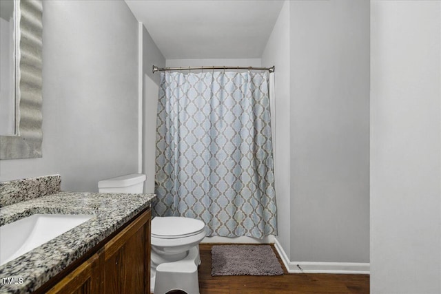 full bath featuring toilet, baseboards, wood finished floors, and vanity