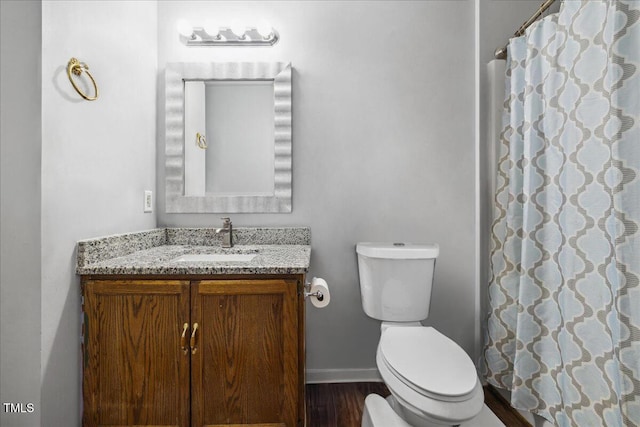 bathroom with a shower with curtain, wood finished floors, vanity, baseboards, and toilet