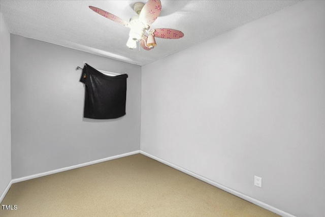 carpeted spare room featuring a textured ceiling and baseboards