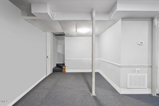 finished basement featuring baseboards, carpet flooring, a drop ceiling, and visible vents