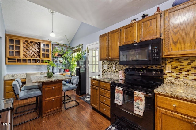 kitchen with brown cabinetry, dark wood-style floors, backsplash, black appliances, and vaulted ceiling