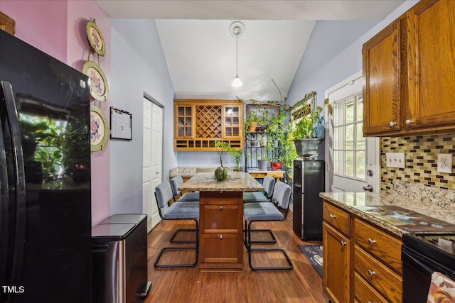 kitchen with freestanding refrigerator, vaulted ceiling, dark wood finished floors, and tasteful backsplash
