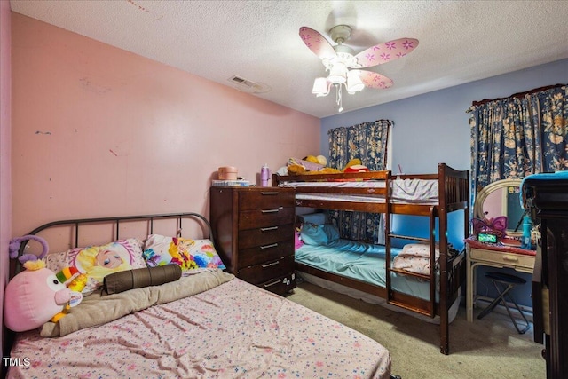 carpeted bedroom with ceiling fan, a textured ceiling, and visible vents