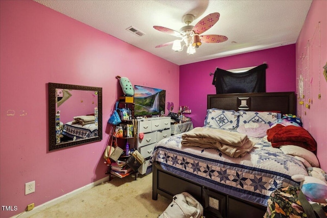 carpeted bedroom featuring a ceiling fan and visible vents