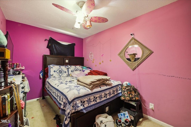 carpeted bedroom featuring baseboards and ceiling fan