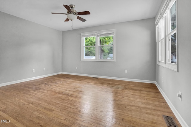 unfurnished room with baseboards, a ceiling fan, light wood-style flooring, and visible vents