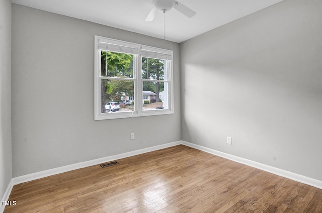 unfurnished room featuring visible vents, baseboards, ceiling fan, and wood finished floors