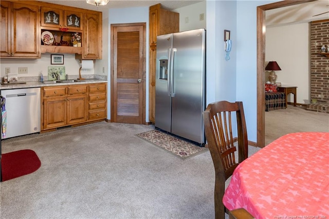 390 Sandy Ridge Rd, Dunn, NC 28334 - kitchen featuring light countertops, stainless steel appliances, brown cabinets, and light colored carpet