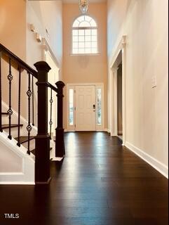 2902 Framer Ln, Durham, NC 27704 - entryway with a high ceiling, stairway, dark wood-type flooring, and baseboards