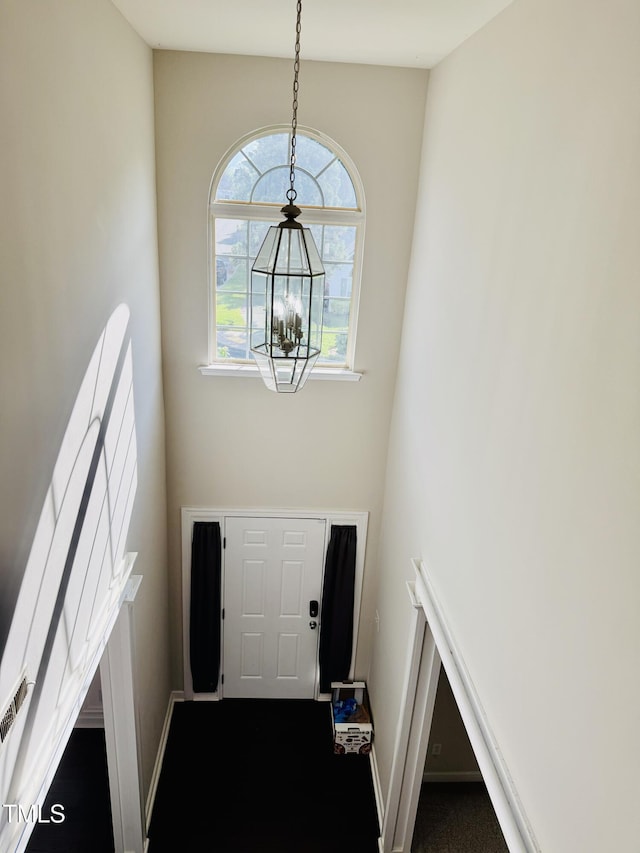 2902 Framer Ln, Durham, NC 27704 - doorway featuring a chandelier, baseboards, and dark carpet