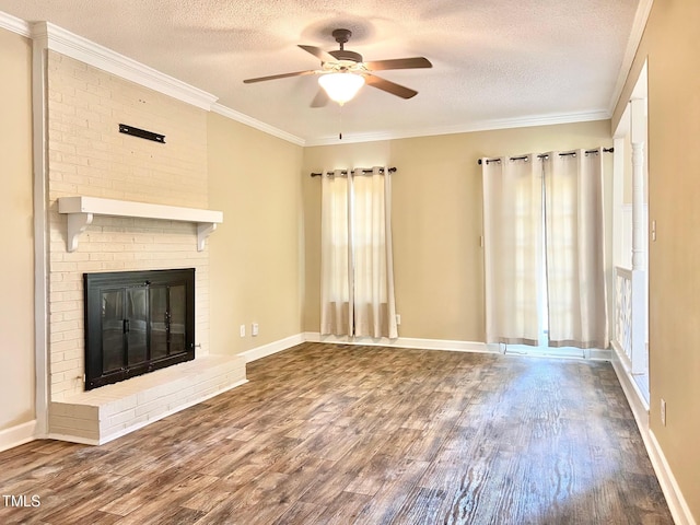 unfurnished living room featuring a brick fireplace, a textured ceiling, ceiling fan, and wood finished floors