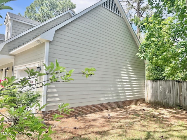 view of property exterior featuring fence and a garage