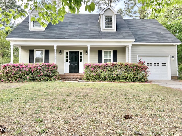 cape cod-style house with a porch, driveway, a front yard, and a garage