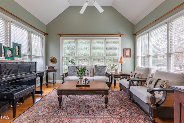 living area featuring ceiling fan, lofted ceiling, light wood-style flooring, and a wealth of natural light