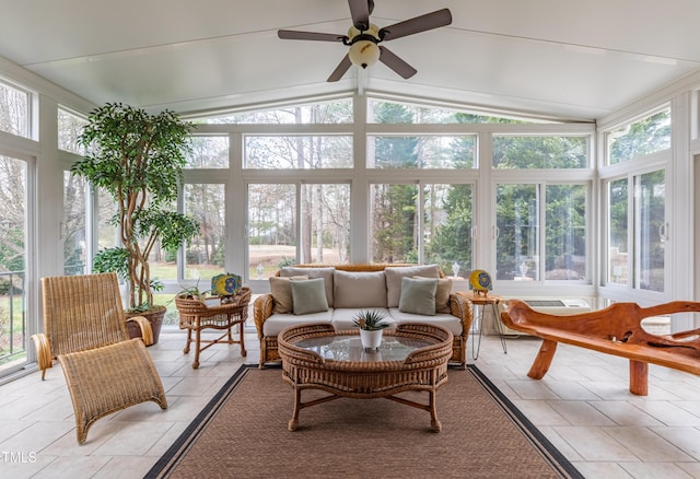 sunroom featuring vaulted ceiling and stone tile floors