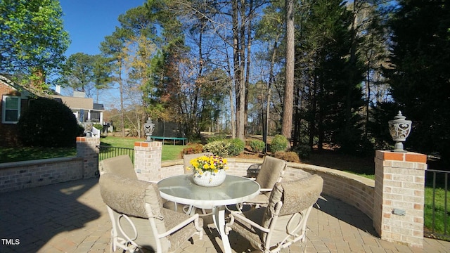 view of patio with outdoor dining area and a trampoline