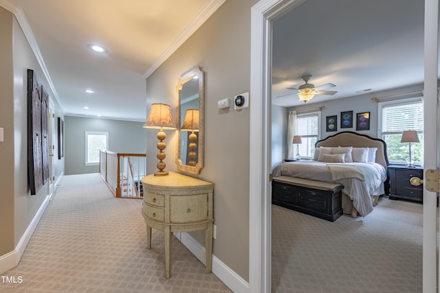 hallway with carpet floors, baseboards, crown molding, and an upstairs landing