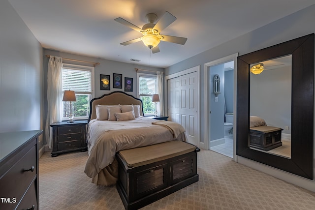 carpeted bedroom with connected bathroom, a ceiling fan, baseboards, and visible vents